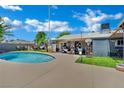 Inviting backyard oasis featuring a pristine pool with tanning ledge and covered patio with leisure furnishings at 4419 Lorna Pl, Las Vegas, NV 89107