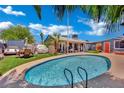 Backyard oasis with a sparkling pool, lush greenery, and a covered patio perfect for entertaining at 4419 Lorna Pl, Las Vegas, NV 89107
