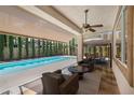 Relax on the covered patio with a ceiling fan, retractable shade, and comfortable seating overlooking the sparkling pool at 5405 San Bellasera Ct, Las Vegas, NV 89141
