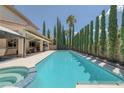 Enjoy the refreshing swimming pool with a spa, surrounded by lush greenery and ample patio space for lounging at 5405 San Bellasera Ct, Las Vegas, NV 89141