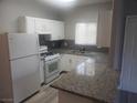 Bright kitchen with granite countertops, white appliances and cabinets, plus new gray flooring at 5655 E Sahara Ave # 2068, Las Vegas, NV 89142