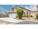 View of the home showcasing a two-car garage, driveway, desert landscaping, and an established shrub at 5816 Glory Canyon Way, Las Vegas, NV 89142