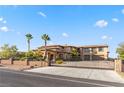 Luxurious home behind a secure gate, surrounded by mature trees and desert landscaping at 670 Du Fort Ave, Henderson, NV 89002