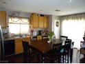 Eat-in kitchen featuring wood cabinetry, a large dining table, and bright, natural light at 6772 Oak Mist St, Las Vegas, NV 89139