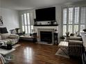 Cozy living room with fireplace, wood floors, plantation shutters, and stylish decor at 682 Corte Madera Ave, Henderson, NV 89015