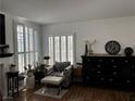 Bright living room featuring plantation shutters, a decorative fireplace and accent chair at 682 Corte Madera Ave, Henderson, NV 89015