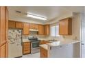 Traditional kitchen with stainless steel appliances, light countertops, and wood cabinets at 6861 Tamarus St # 203, Las Vegas, NV 89119