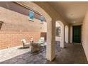 Private outdoor patio featuring brick flooring, comfortable seating, and a covered area at 7194 Sage Wren Ct, Las Vegas, NV 89148
