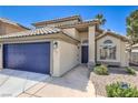 Charming home exterior with tile roof, blue garage door, and desert landscaping at 7633 Raven Hills Dr, Las Vegas, NV 89149