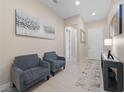 Bright foyer with neutral walls, modern decor, and two armchairs creates a welcoming entrance at 80 Cathedral Wash Pl, Henderson, NV 89011