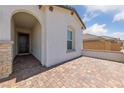 Home front porch features brick-paved entrance with arched doorway and stone pillar at 80 Cathedral Wash Pl, Henderson, NV 89011