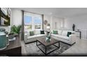Bright living room with neutral decor, large windows, and comfortable seating, creating an inviting and relaxing space at 871 Apatite Pl # Lot 54, Henderson, NV 89011