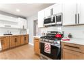 Close-up of kitchen featuring stainless steel stove, white tile backsplash, and wood cabinets at 915 Melrose Dr, Las Vegas, NV 89101