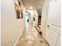 Inviting hallway featuring neutral paint and tile floors leading to an upstairs staircase at 9648 Spyglass Run Ave, Las Vegas, NV 89178