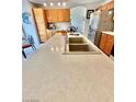 Close up of kitchen counter with a large sink, faucet, and breakfast bar at 10500 Horseshoe Falls Ct, Las Vegas, NV 89144
