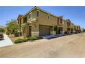 Exterior view showcasing a modern townhome with an attached garage and well-maintained landscaping at 12282 Azure Gate Rd # 4, Las Vegas, NV 89183