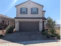 Two-story home featuring a paver driveway, a two-car garage, manicured landscaping, and mountain views at 2343 Teatro Ave, Henderson, NV 89044