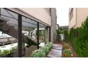 Modern home exterior features a landscaped walkway, large windows, a glimpse of an open kitchen and stairwell at 3961 Heron Fairway Dr, Las Vegas, NV 89141