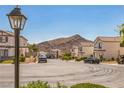 Neighborhood street view showcasing well-maintained homes and mountain in the background on a clear day at 4415 Peaceful Harbor St, Las Vegas, NV 89129