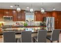 Modern kitchen featuring dark wood cabinets, stainless steel appliances, and a large black countertop island at 51 Morning Mimosa Ct, Henderson, NV 89012