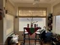 Cozy dining area featuring a small table, two chairs, and a bright window with blinds at 5196 Mandalay Springs Dr # 101, Las Vegas, NV 89120