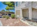 Condo exterior featuring desert landscaping, walkway, and a covered parking area in background at 5196 Mandalay Springs Dr # 101, Las Vegas, NV 89120