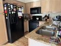 Functional kitchen featuring updated stainless steel appliances, granite countertops, and wood cabinets at 5196 Mandalay Springs Dr # 101, Las Vegas, NV 89120