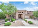 Beautifully landscaped two-story home with a stone facade, covered porch and a convenient two-car garage at 5542 Oak Bend Dr, Las Vegas, NV 89135