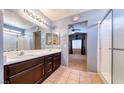 Bathroom featuring a double sink vanity, tile floors, and a glass door shower enclosure at 6058 Grape Blossom Ave, Las Vegas, NV 89142