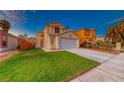 Inviting two-story home with a well-maintained lawn and attached two-car garage at 6058 Grape Blossom Ave, Las Vegas, NV 89142