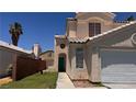Inviting two-story house with a tan stucco finish, a tiled roof, and a well-kept lawn leading to the front door and garage at 6058 Grape Blossom Ave, Las Vegas, NV 89142