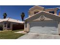 A well-maintained two-story home featuring a clean, white two-car garage and beautiful landscaping at 6058 Grape Blossom Ave, Las Vegas, NV 89142