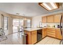 Cozy eat-in kitchen with tile floors, wood cabinets and a sliding door to the backyard at 6058 Grape Blossom Ave, Las Vegas, NV 89142