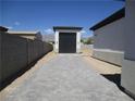 Paved driveway leading to a modern garage and home exterior, set against a clear blue sky at 6075 Dapple Gray Rd, Las Vegas, NV 89149