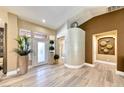 Bright foyer with high ceilings, decorative plants, and unique wall accents create an inviting entrance at 7311 Chaparral Cove Ln, Las Vegas, NV 89131