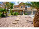 Charming two-story home featuring desert landscaping, a stepping stone walkway, and a two-car garage at 7340 Elderly Ave, Las Vegas, NV 89131