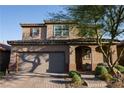 Charming two-story home featuring a red brick driveway, attached garage, and welcoming front porch at 777 Star Apple Ln, Las Vegas, NV 89178