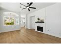 Bright living room with a modern ceiling fan, fireplace, and wood-look floors at 8312 Raphael Ct, Las Vegas, NV 89129