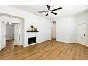 Bright and airy living room featuring wood-look floors, white brick fireplace, and modern ceiling fan at 8312 Raphael Ct, Las Vegas, NV 89129