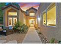 Inviting courtyard features comfortable seating, desert landscaping, and a paved walkway to the home's entrance at 8370 Plum Creek Ct, Las Vegas, NV 89113