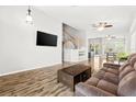 Bright living room featuring wood floors, a ceiling fan, and a staircase at 981 Leadville Meadows Dr, Henderson, NV 89052