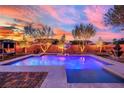 Backyard pool and spa area with mature trees and landscape lighting at 9906 Stiges St, Las Vegas, NV 89178