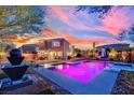 Resort-style backyard with a sparkling pool, a basketball hoop, and lush landscaping at 9906 Stiges St, Las Vegas, NV 89178