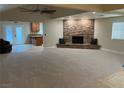 Spacious living room boasts a stone fireplace, plush carpeting, and an open layout to the kitchen at 1006 Bel Air Cir, Las Vegas, NV 89109