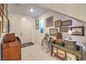 Bright foyer featuring white tile floors, a window, and decorative vintage furniture at 10140 Magnolia Creek St, Las Vegas, NV 89141