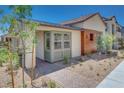 Inviting home showcasing a wood panel accent, large window, desert landscaping, and brick paved walkway at 1021 Golden Summit Dr, Las Vegas, NV 89138