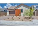 Charming single-story home featuring a brown garage door, a wood panel accent, and desert landscaping at 1021 Golden Summit Dr, Las Vegas, NV 89138