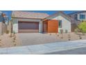 Charming single-story home featuring a brown garage door, a wood panel accent, and desert landscaping at 1021 Golden Summit Dr, Las Vegas, NV 89138