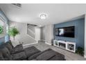 Comfortable living area with neutral paint, wood-look tile flooring, and a fireplace at 106 Basketflower Ct, Las Vegas, NV 89183