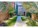 Inviting front entrance with walkway, manicured lawn, and vibrant greenery at 11271 Winter Cottage Pl, Las Vegas, NV 89135